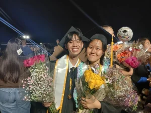 Seniors Zion Borriboonratana and Han Song share an emotional moment together after the ceremony. Once seniors were dismissed, students could wear the many leis and boquets their loved ones brought them. Photo taken by Zion Borriboonratana.